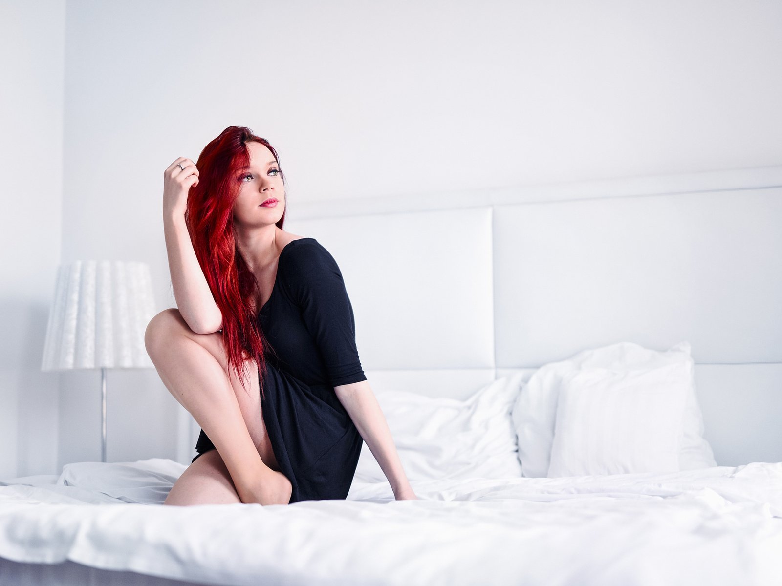Красивая рыжая девушка голой позирует в кровати