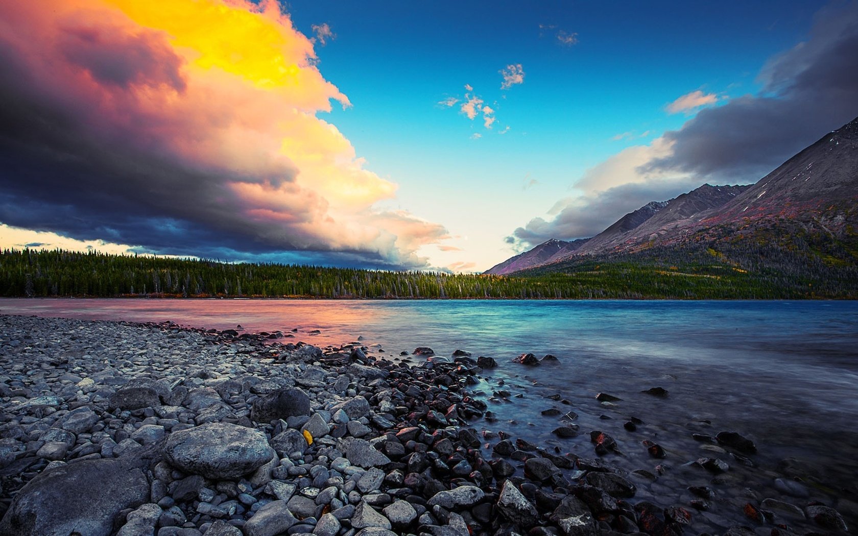 Обои небо, облака, деревья, река, горы, камни, лес, закат, the sky, clouds, trees, river, mountains, stones, forest, sunset разрешение 1920x1200 Загрузить