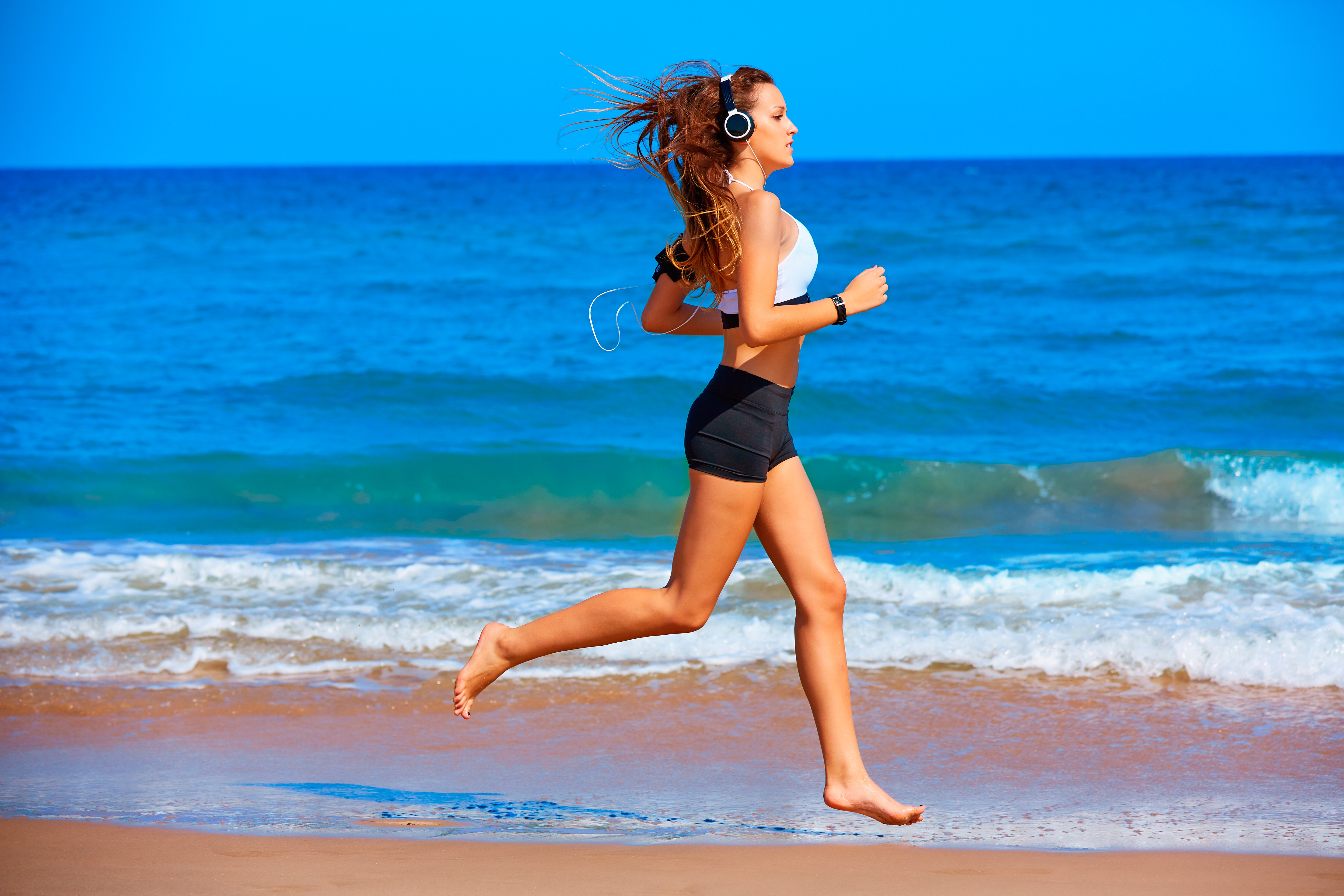 Красивые девушки с сексуальными телами занимаются пробежкой по пляжу 