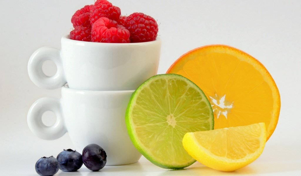 Обои малина, чашки, фрукты, цитрусы, лимон, ягоды, апельсин, лайм, дольки, черника, raspberry, cup, fruit, citrus, lemon, berries, orange, lime, slices, blueberries разрешение 2048x1297 Загрузить