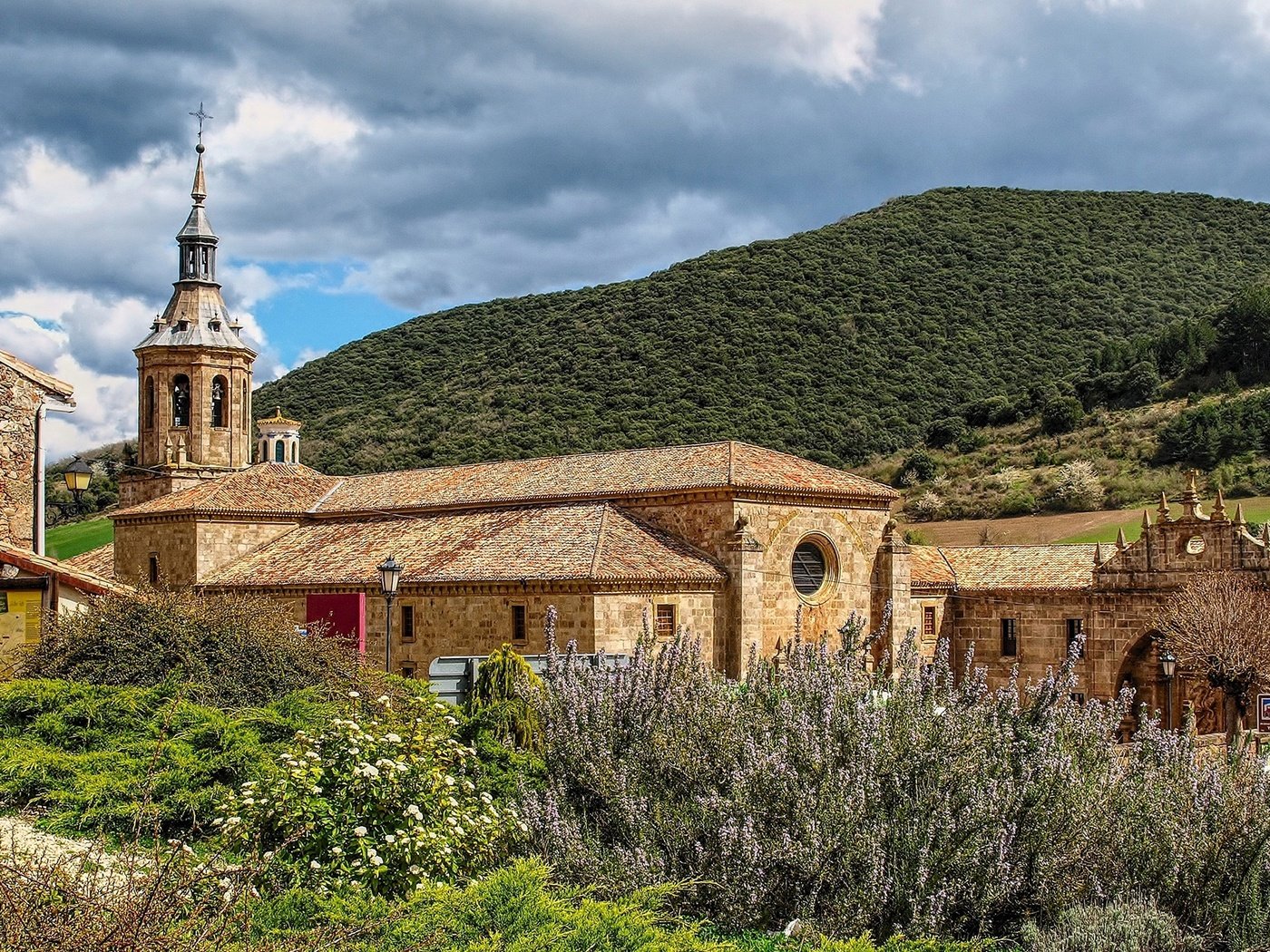 Обои небо, монастырь, трава, la rioja, monasterio de yuso, облака, горы, солнце, лес, кусты, испания, the sky, the monastery, grass, clouds, mountains, the sun, forest, the bushes, spain разрешение 1920x1253 Загрузить