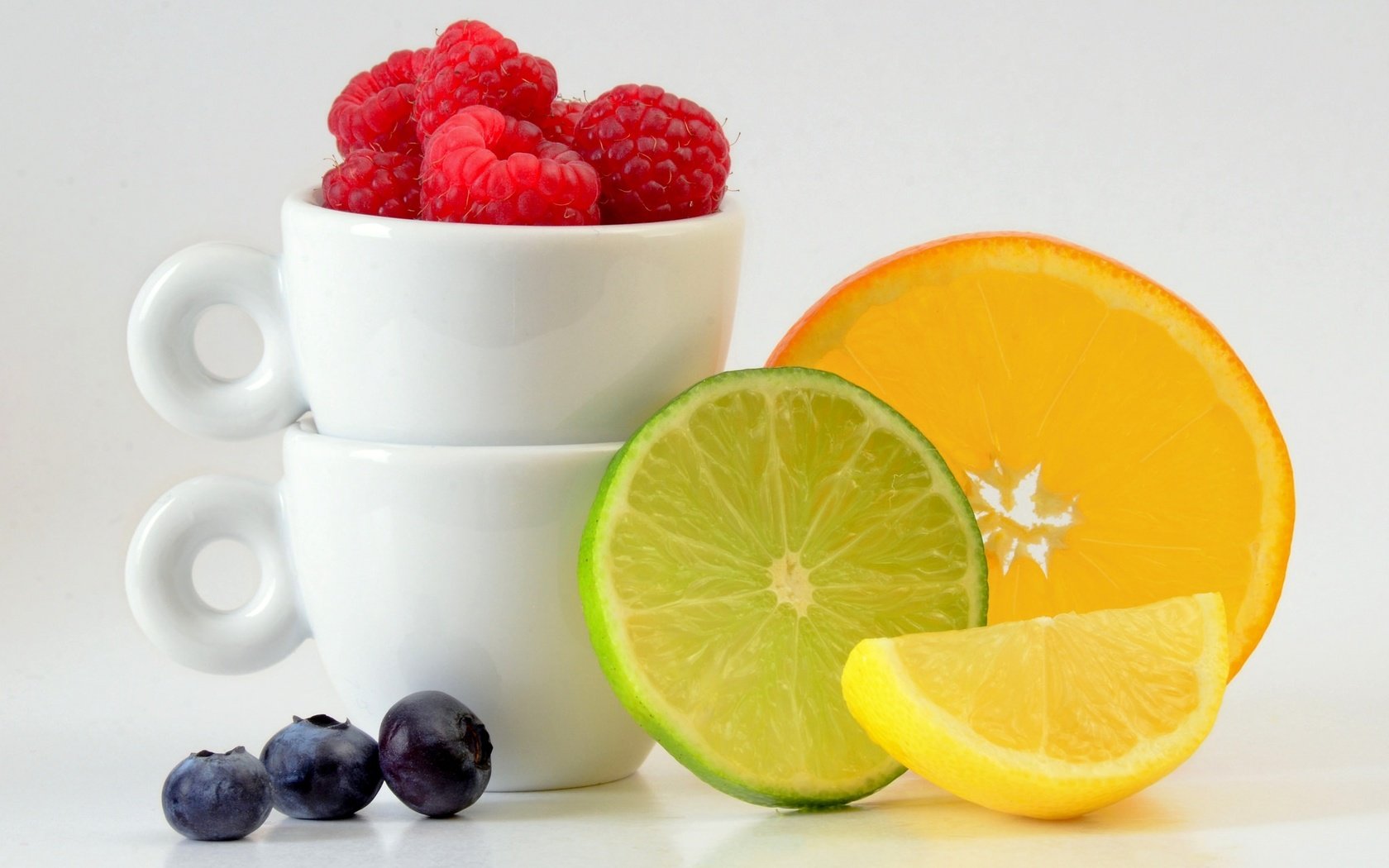 Обои малина, чашки, фрукты, цитрусы, лимон, ягоды, апельсин, лайм, дольки, черника, raspberry, cup, fruit, citrus, lemon, berries, orange, lime, slices, blueberries разрешение 2048x1297 Загрузить