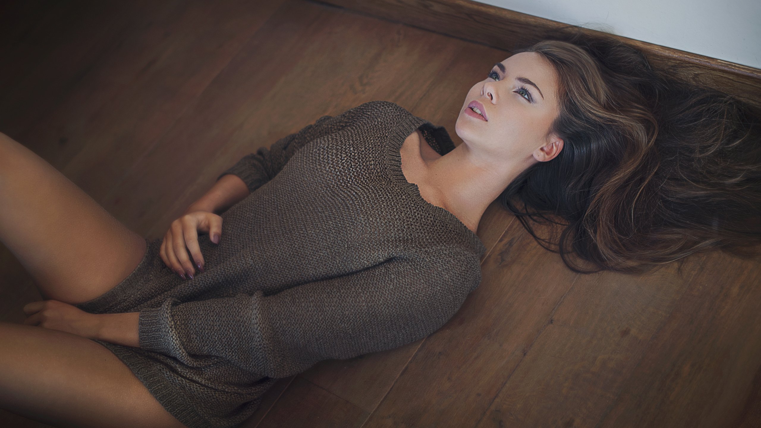 Девушка в свитере лежит