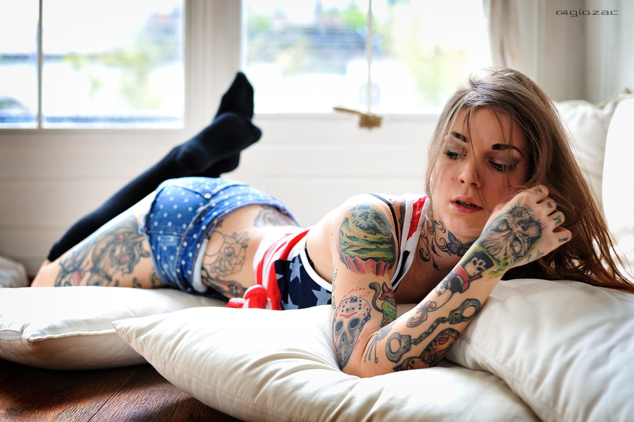 Татуированная девушка лежит